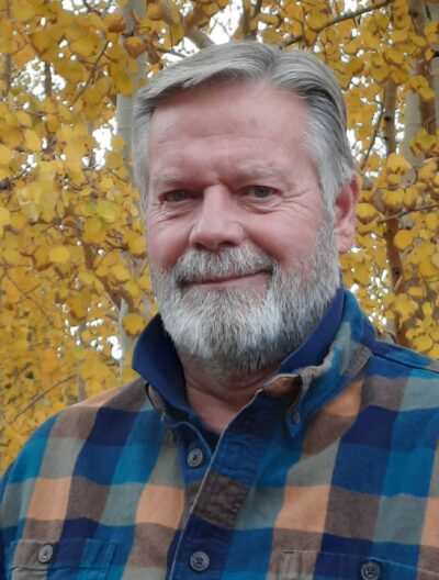 Portrait of John W. Anderson in front of golden aspen trees
